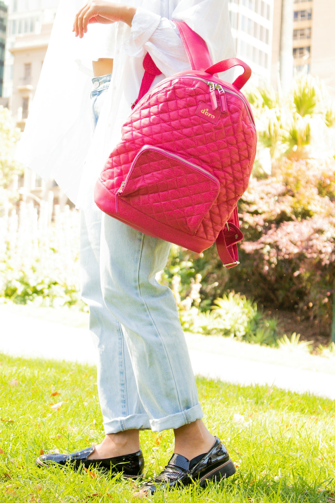 person in white shirt and blue denim jeans with red backpack
